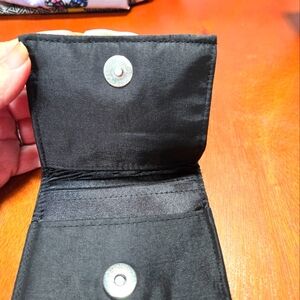 Ladies black wallet with big white and black flower on the front.
